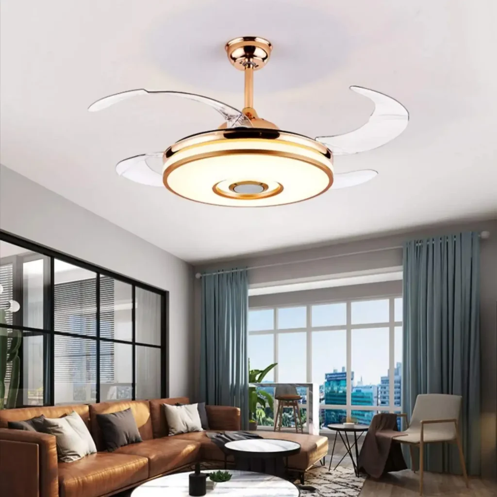 Modern living room with large windows, a brown leather sofa, a round coffee table, and a gold and white ceiling fan with lights.