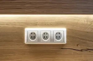 Three electrical power outlets on a wooden surface, highlighting concerns like "Why Do Power Points Spark When Plugging In.
