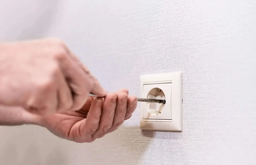 Electrician repairing a wall outlet in Tweed Heads for Blue Ridge Electrical services.