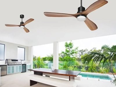 Outdoor patio with ceiling fans, a wooden table with benches, a barbecue grill, and a view of a pool and greenery.