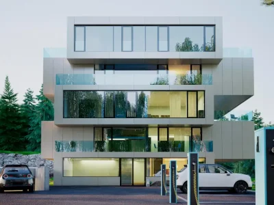 Modern multi-story building with large glass windows and electric vehicle charging stations in the foreground, surrounded by trees.